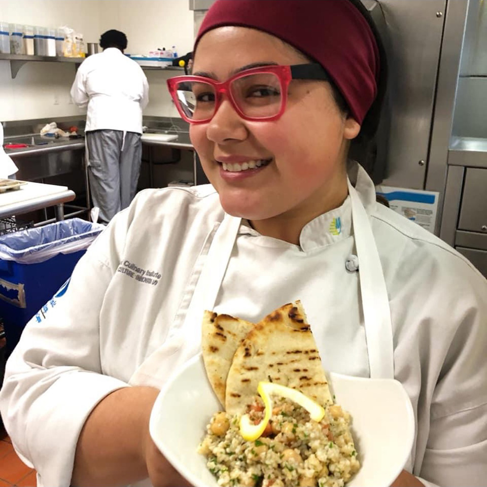 Executive Chef, Ashley Esposito holding a plate of food