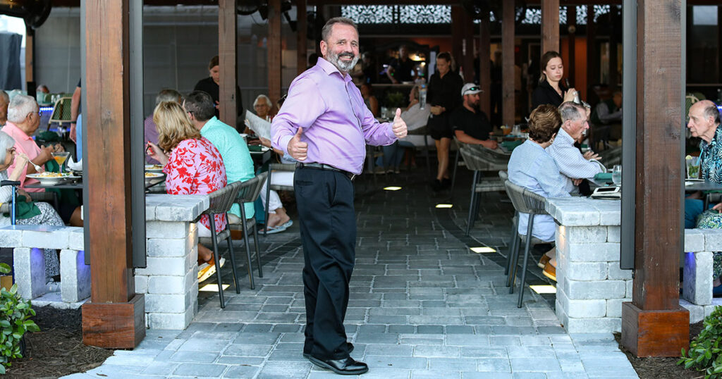 manager Sam D’Amico in the outdoor dining courtyard at Magnolias on the Bay on Manasota Key