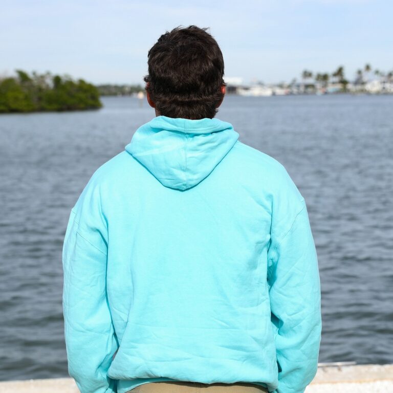 man wearing Lock 'N Key Unisex Fleece Hooded Sweatshirt with intracoastal waterway in the background - back view